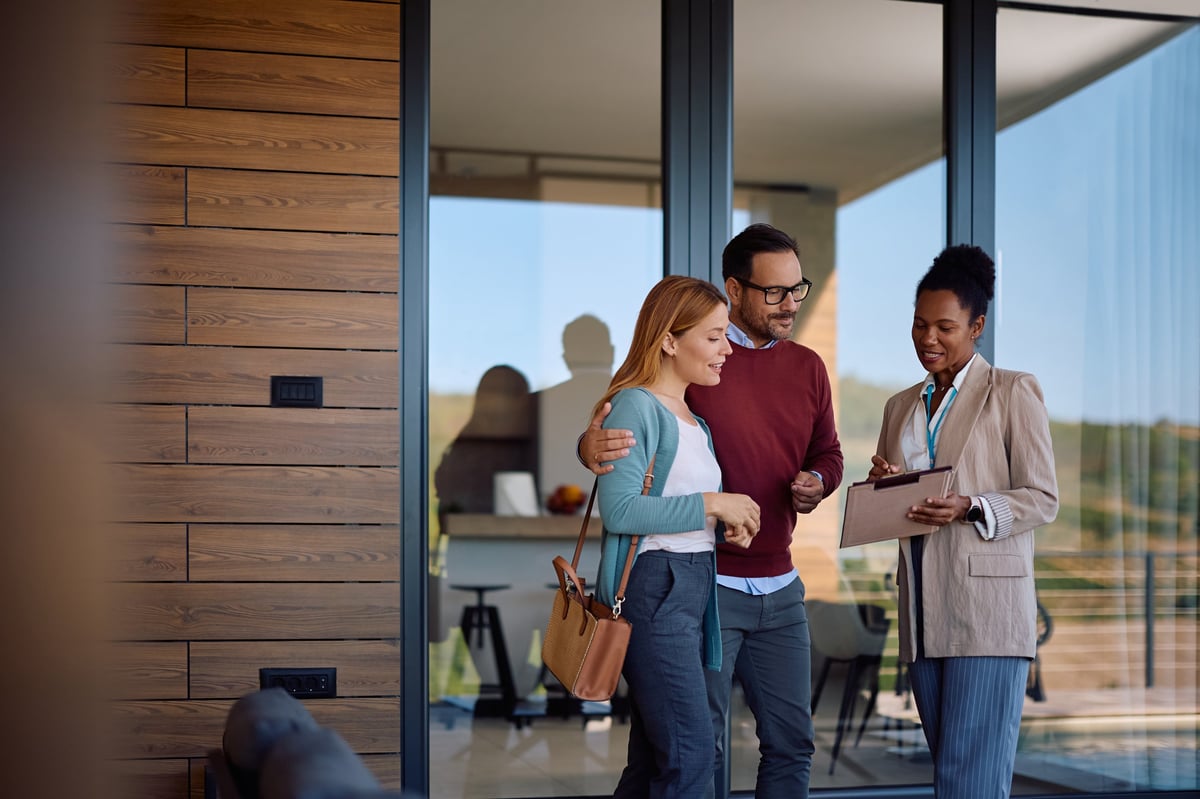 A real estate professional reviewing housing plans with a couple
